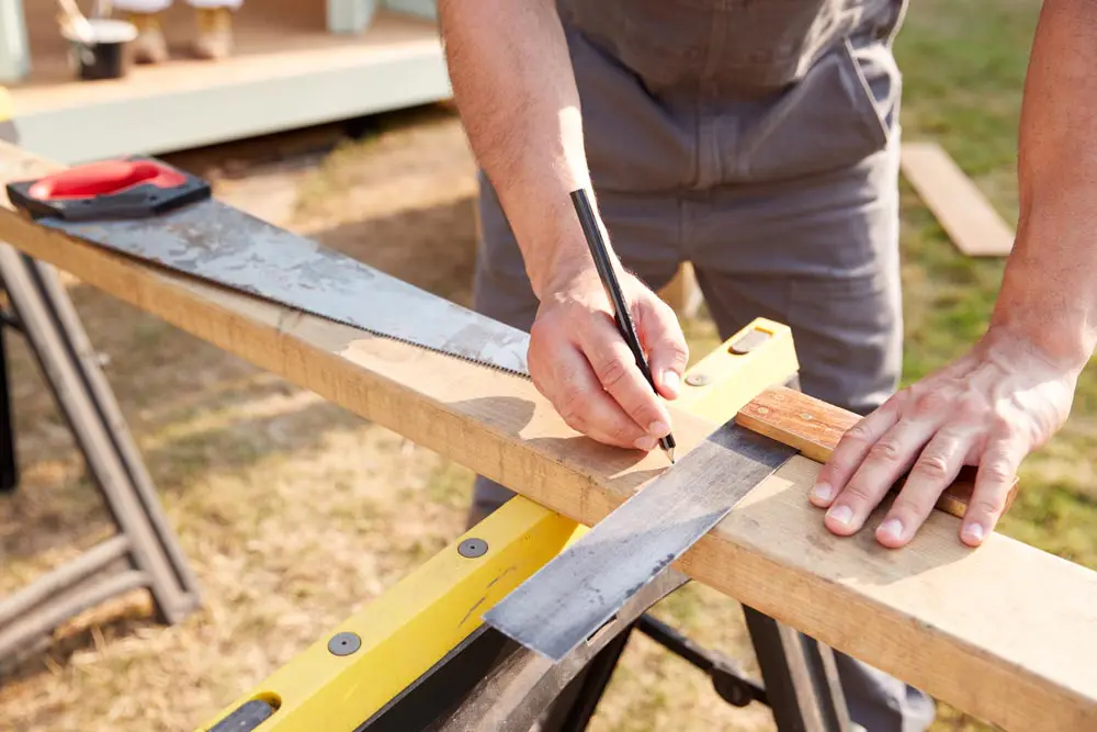 Tradesman-Insurance-close-up-male-carpenter-measuring-wood-SJL-Insurance-Services