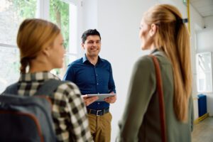 principal talking to mother and daughter about admission to high school